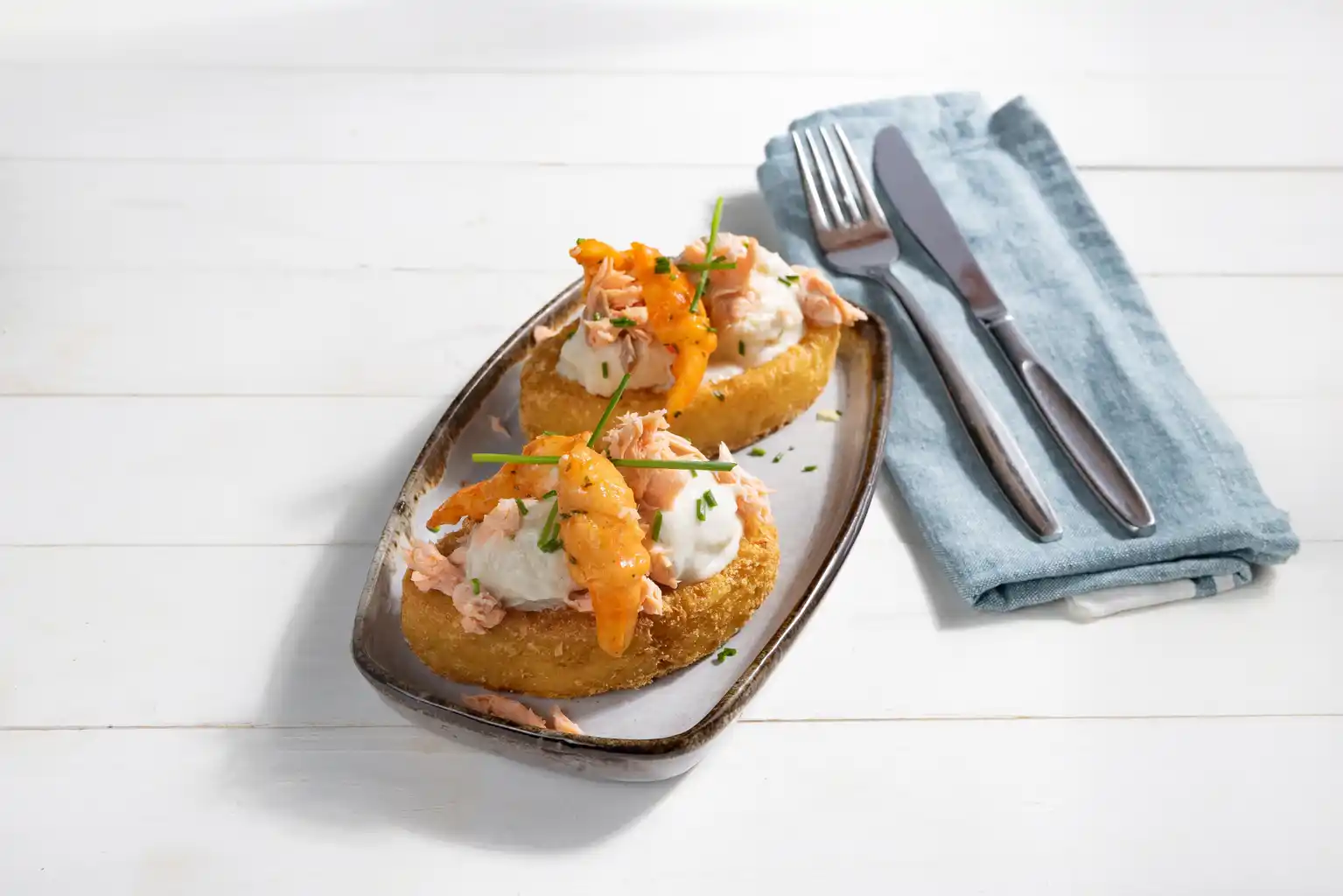 Rostibootje gevuld met tongrolletje en warm gerookte zalm en krabpootjes